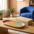 Colorful scalloped catchall tray beside a plain beige box in a sunlit living room